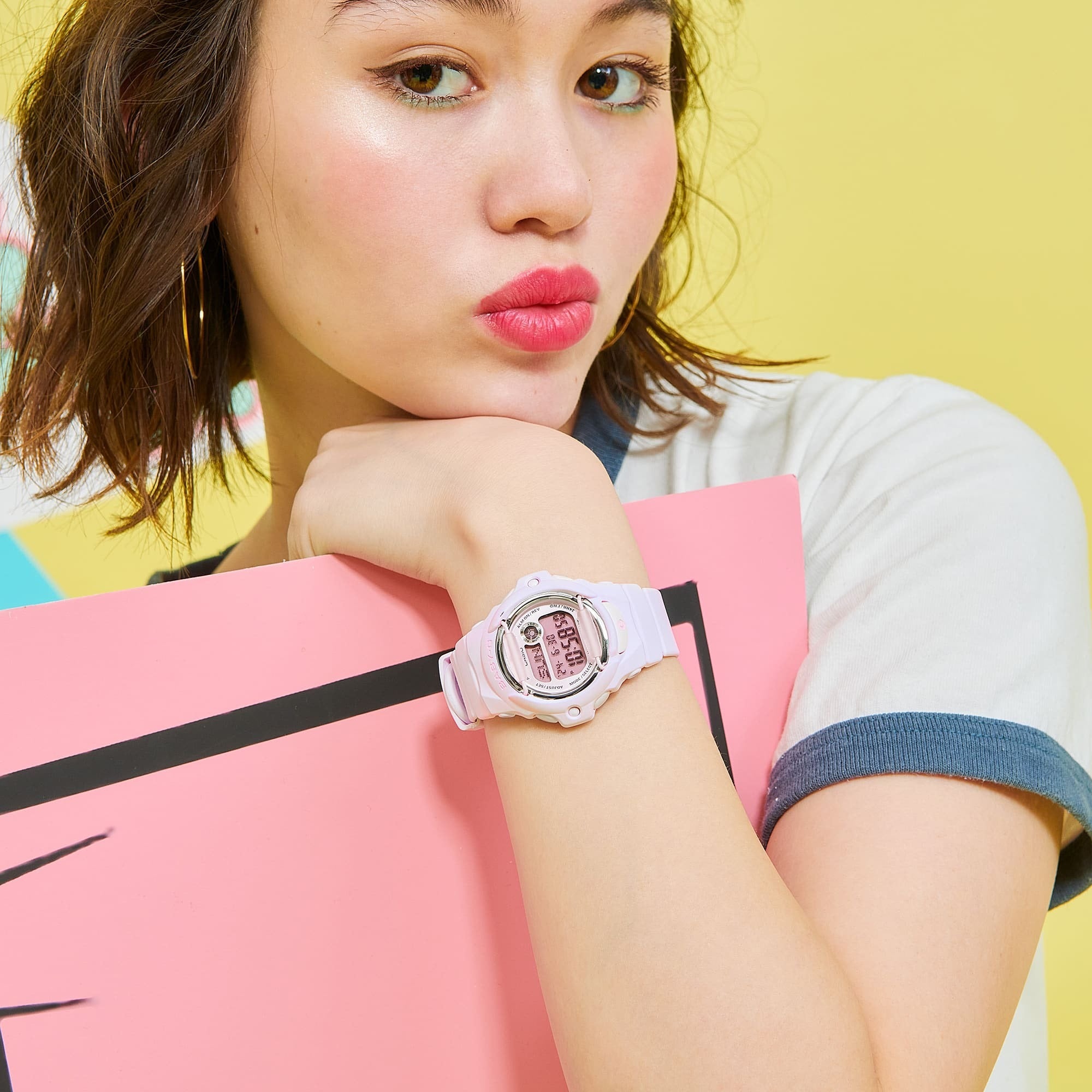 Casio Baby-G BG-169M-4DR worn on wrist, close-up lifestyle shot with yellow backdrop