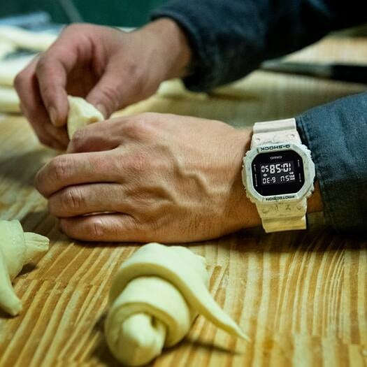 Casio G-Shock DW-5600WM-5DR watch worn on wrist while kneading dough, lifestyle shot
