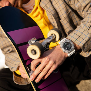 Casio G-Shock GA-900SKL-7AER worn on wrist, lifestyle shot with skateboard
