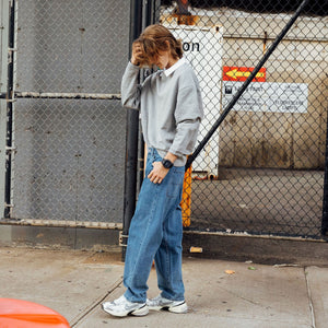 Casio G-Shock GX-56BB-1DR worn on wrist, urban lifestyle shot by a fence
