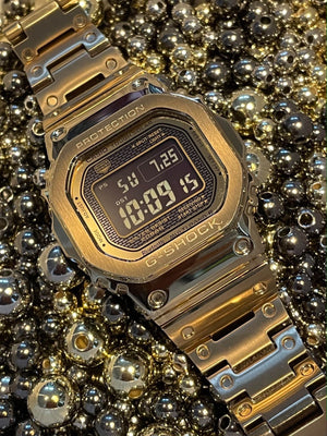 Casio G-Shock GMW-B5000GD-9DR Gold Stainless Steel Wristwatch Product shot with Jewellery background 