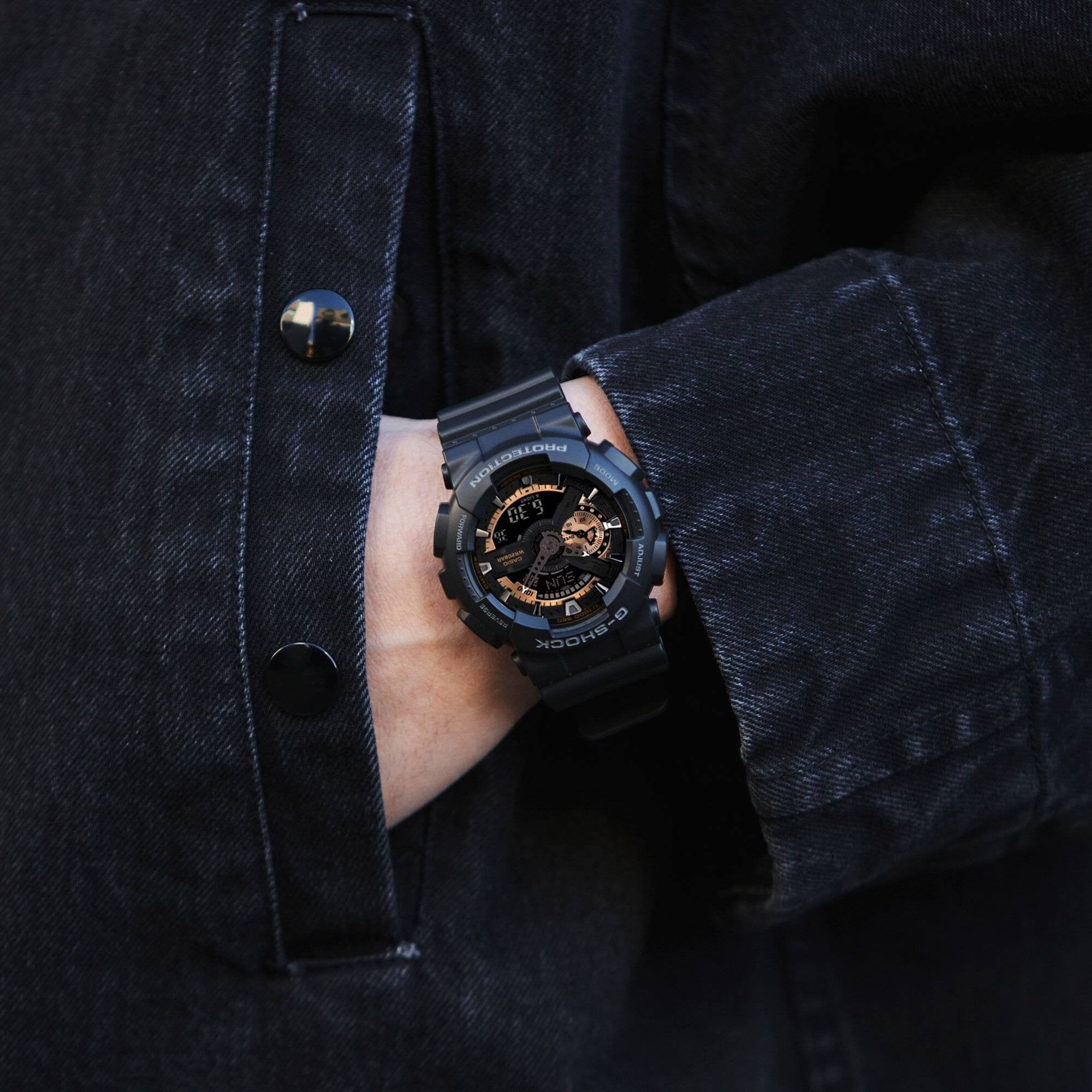 Casio G-Shock GA-110RG-1AER watch worn on wrist peeking from a dark denim jacket sleeve