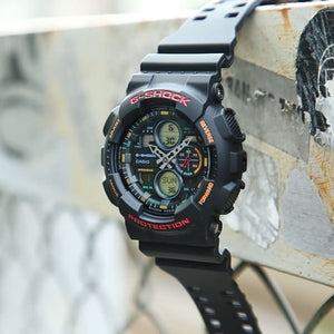 Casio G-Shock GA-140-1A4ER watch propped outdoors on a rusty pipe, lifestyle shot
