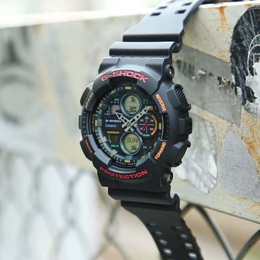 Casio G-Shock GA-140-1A4ER watch propped outdoors on a rusty pipe, lifestyle shot