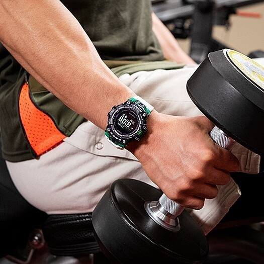 Casio G-Shock GBD-100SM-1A7ER worn on wrist during a dumbbell workout, gym lifestyle shot