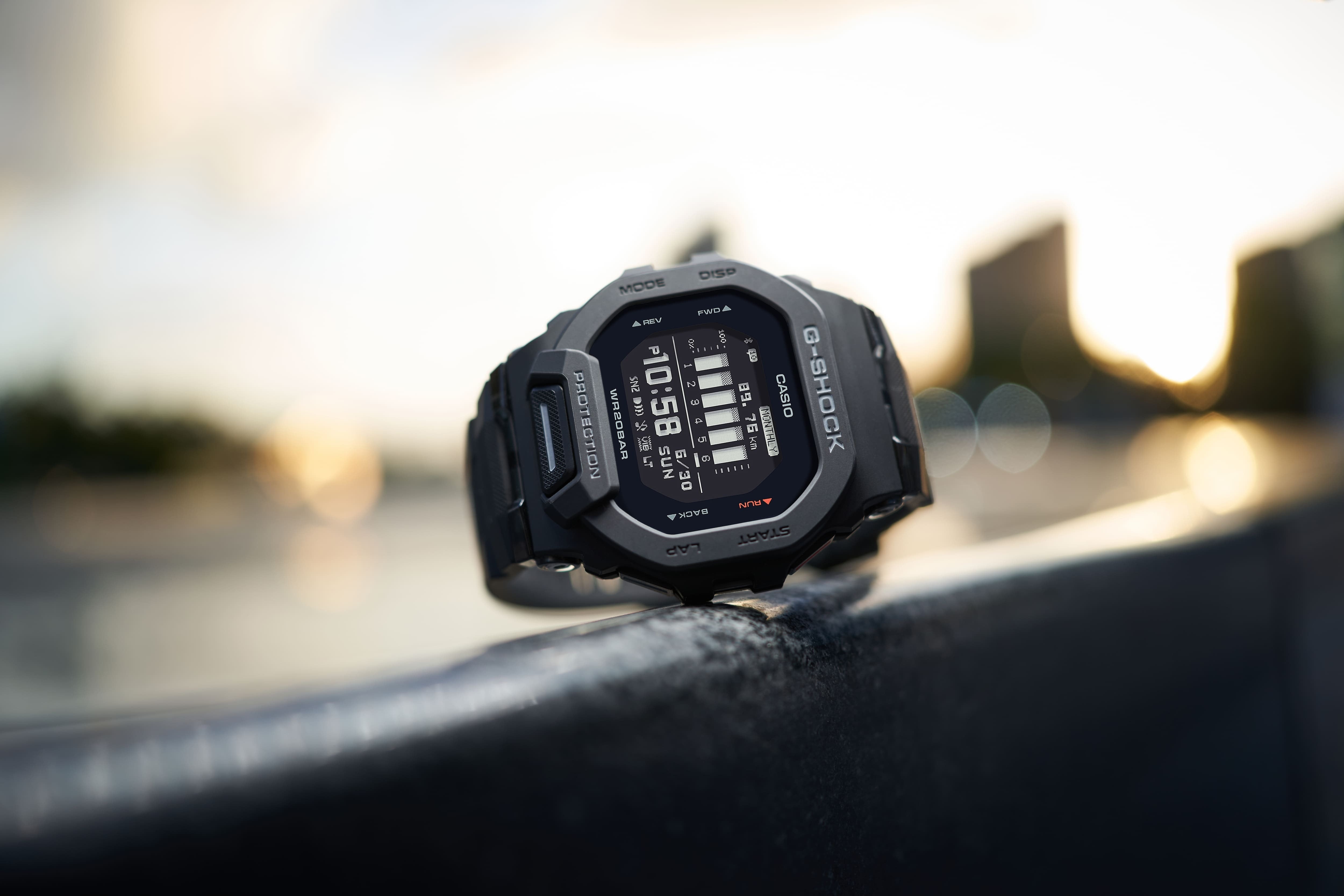 Casio G-Shock GBD-200-1DR watch propped outdoors at sunrise, lifestyle shot on a metal railing