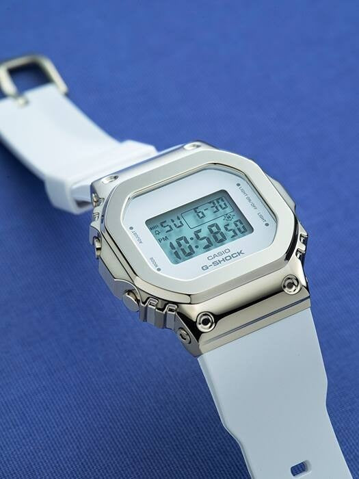 Casio G-Shock GM-S5600G-7ER angled view on blue background showing gold-tone bezel