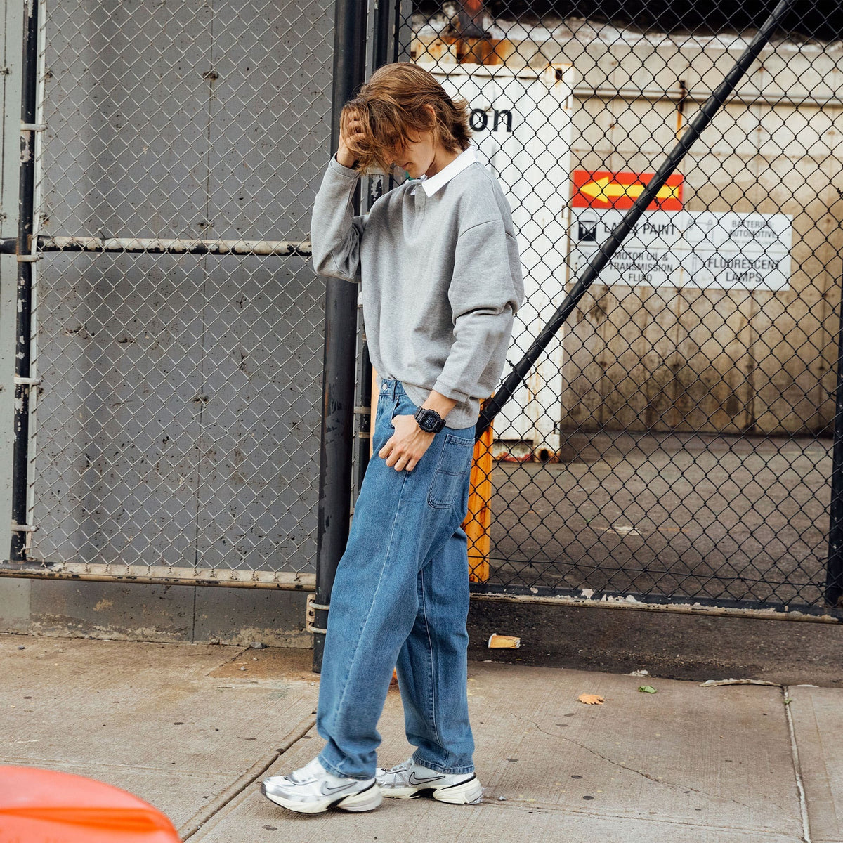 Casio G-Shock GX-56BB-1DR worn on wrist, urban lifestyle shot by a fence